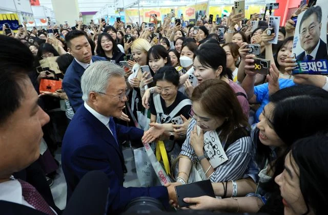 문재인 전 대통령과 부인 김정숙 여사가 18일 서울 강남구 삼성동 코엑스에서 열린 2025 서울국제도서전 평산책방 부스를 찾아 방문객들과 인사를 나누고 있다. 뉴스1