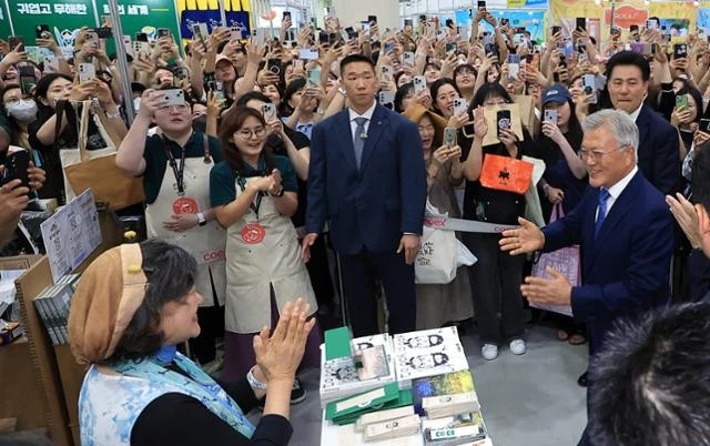 문재인 전 대통령이 18일 서울 강남구 삼성동 코엑스에서 열린 2025 서울국제도서전을 찾아 평산책방 부스 앞에서 백창화 작가와 만나고 있다. 뉴스1